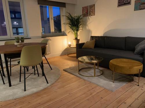 a living room with a couch and a table at De zwarte deur in Genk