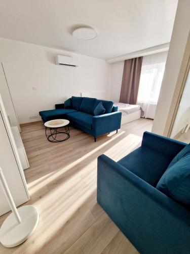 Apartments in Lazdijai في لازديجاي: غرفة معيشة مع أريكة زرقاء وطاولة