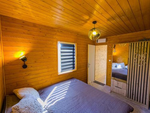 1 dormitorio con 1 cama en una habitación de madera en Cosa Nostra Apartman, en Sárvár