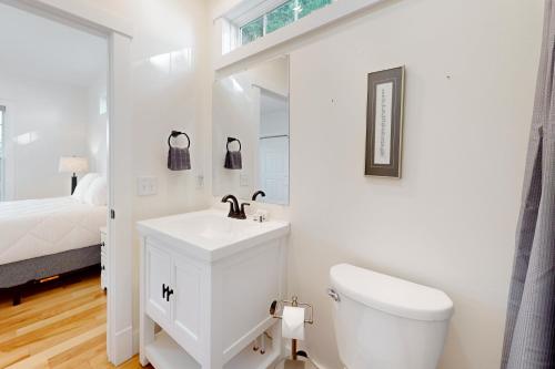 La salle de bains blanche est pourvue de toilettes et d'un lavabo. dans l'établissement The Lakewood, à Swanton