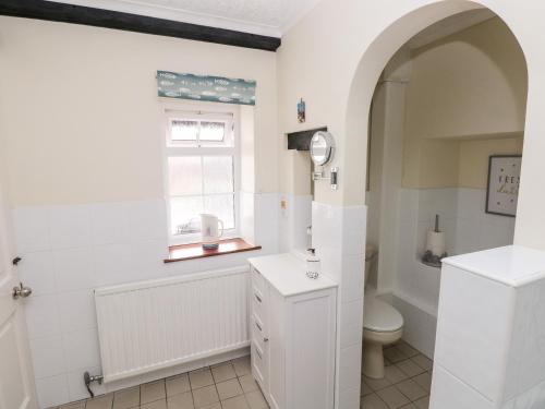 a bathroom with a toilet and a window at The Stables in Flemingston