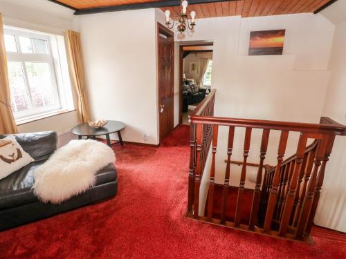 a living room with a couch and a stair case at The Stables in Flemingston