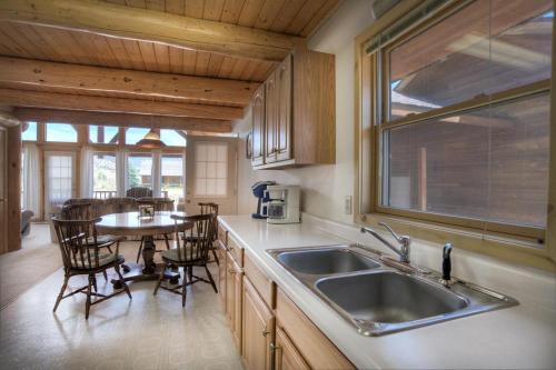 cocina con fregadero y mesa con sillas en Moonlight Cabin, en Creede