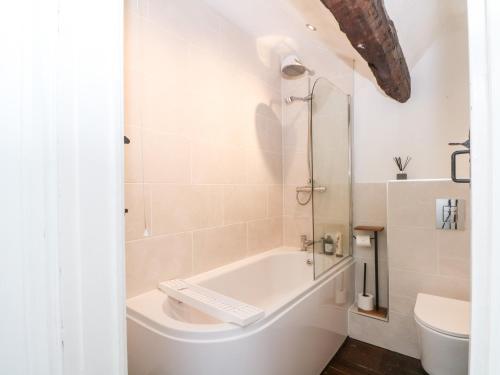 une salle de bain blanche avec une baignoire et des toilettes dans l'établissement Hunters Cottage, à Bakewell