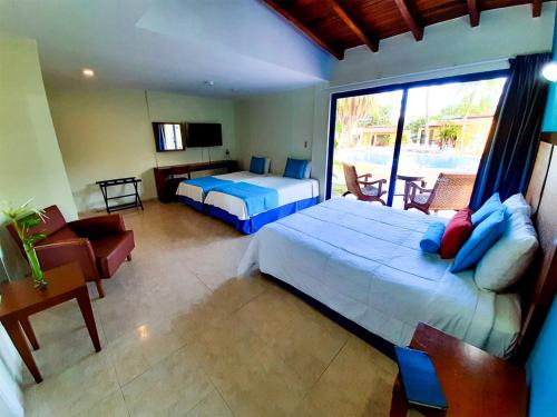 a bedroom with two beds and a balcony at Hesperia Playa el Agua in El Agua