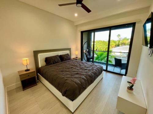 1 dormitorio con cama y ventana grande en The Botanicals Las Olas Near Beach, en Fort Lauderdale