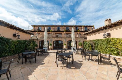 a patio with tables and chairs in front of a building at Cigarral de Caravantes in Toledo