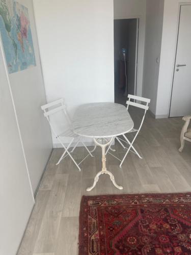 une table et une chaise dans une chambre avec un tapis dans l'établissement Satine, à Perpignan