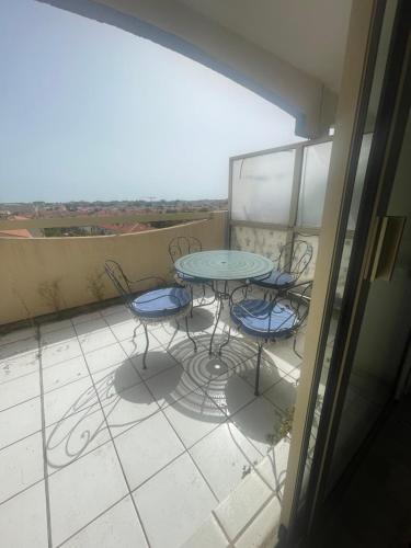 un patio avec une table et des chaises sur un balcon dans l'établissement Satine, à Perpignan