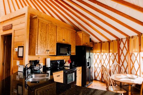 una cocina con armarios de madera y una mesa con mesa. en Fontana @ Sky Ridge Yurts, en Bryson City