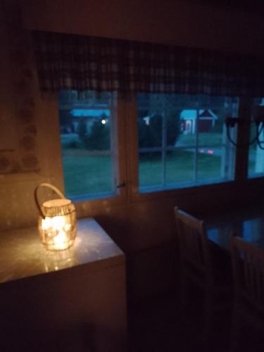 uma vela sentada numa mesa em frente a uma janela em Wild nature em Kuhmo