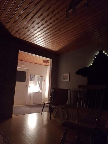 a living room with a wooden ceiling and a door at Wild nature in Kuhmo
