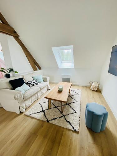 a living room with a couch and a coffee table at Domaine de la Quenouille Appt A in Péronne