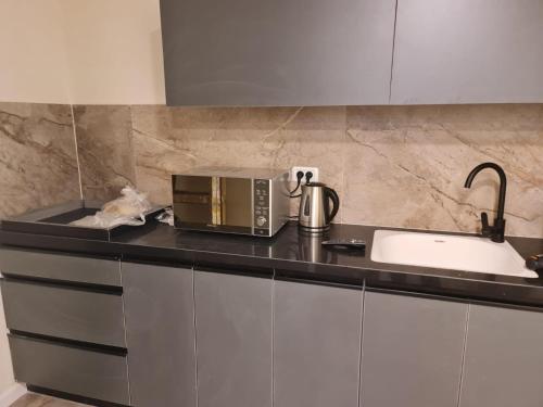 a kitchen counter with a microwave and a sink at Apartment in Akko in Acre