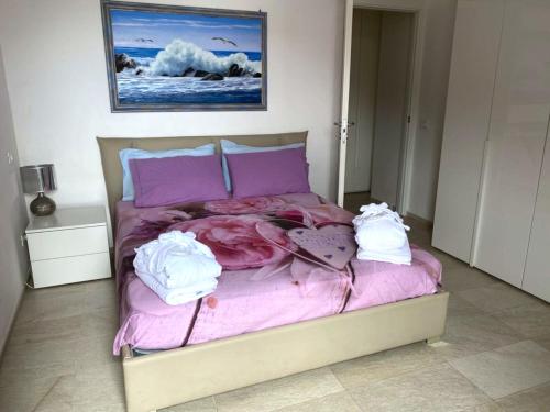 a bed with purple sheets and white towels on it at Estate Riomaggiore in Riomaggiore