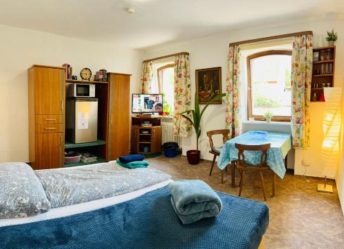 1 dormitorio con 2 camas, mesa y escritorio en Apartment Amelie - Zimmer mit TV, W-Lan, Mikrowelle und Kühlschrank, Bad mit Dusche, en Malterdingen