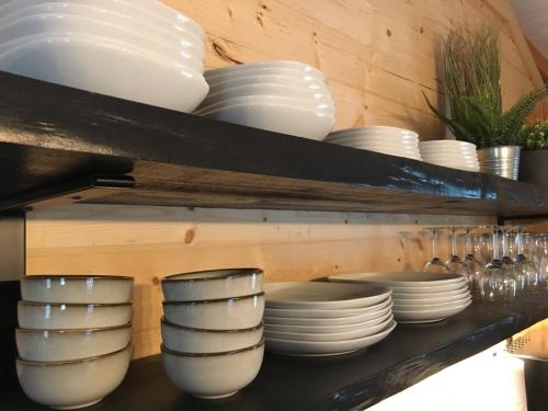 un estante con placas blancas y cuencos. en Junaluska @ Sky Ridge Yurts, en Bryson City
