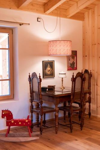 a dining room with a wooden table and chairs at Haus Himmelfahrt in Soprabolzano