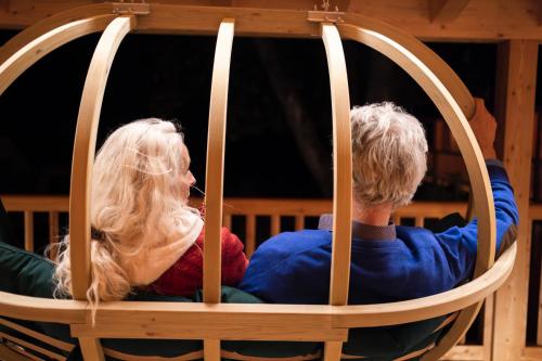 a man and a woman sitting in a wooden chair at Haus Himmelfahrt in Soprabolzano