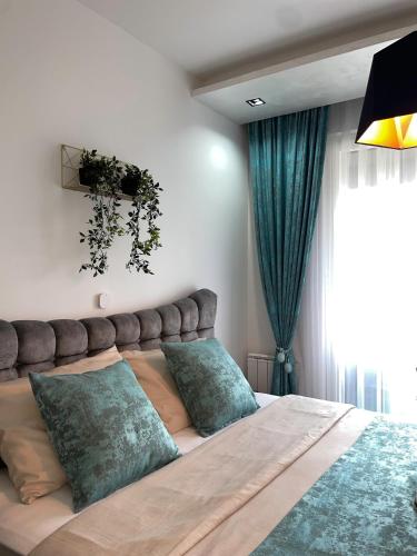 een slaapkamer met een groot bed met groene kussens bij Emma Park Lake Emma Parklake in Tuzla