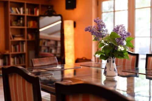 a table with a vase of purple flowers on it at Haus Himmelfahrt in Soprabolzano