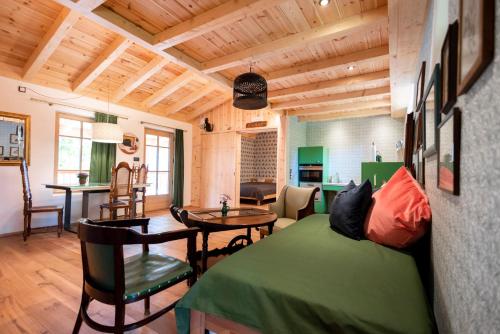 a bedroom with a green bed and a dining room at Haus Himmelfahrt in Soprabolzano