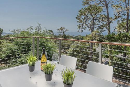 a table with chairs and a bottle of wine on a balcony at 3904 Out of the Blue home in Carmel