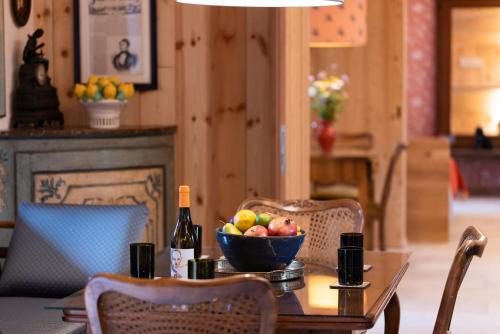 a table with a bowl of fruit and a bottle of wine at Haus Himmelfahrt in Soprabolzano