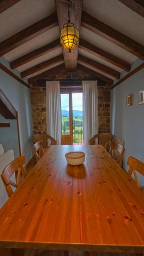 a large wooden table in a room with a window at Posada Venta Hornizo in Arenas de Iguña