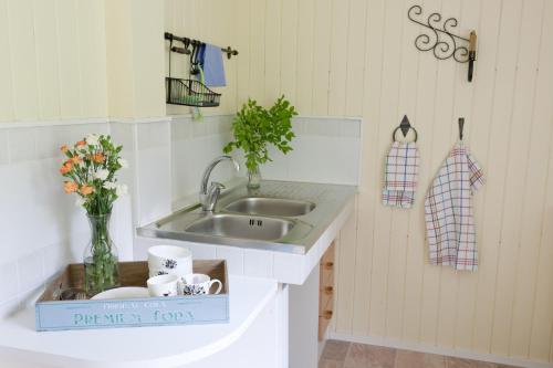 a kitchen with a sink and a vase of flowers at Soltorp Eco Lodge in Porvoo