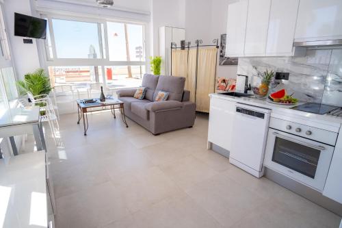 cocina y sala de estar con sofá y mesa en MARÍTIMO28, en Cádiz
