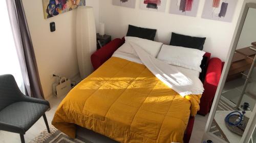 1 dormitorio con 1 cama con manta amarilla y espejo en La Casetta, en Caltabellotta