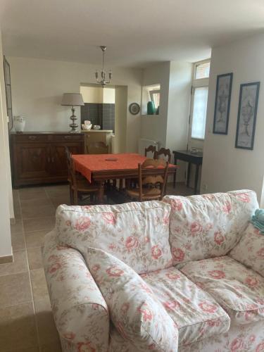 a living room with a couch and a table at Maison place champs de foire 6 pers 4 chambres jardin terrasse in Chamberet