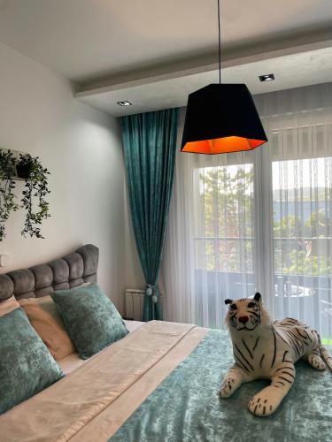 a bedroom with a tiger laying on the bed at Emma Park Lake Emma Parklake in Tuzla