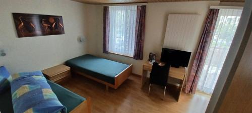 a small living room with a bed and a tv at Hotel / Restaurant Post in Eschlikon