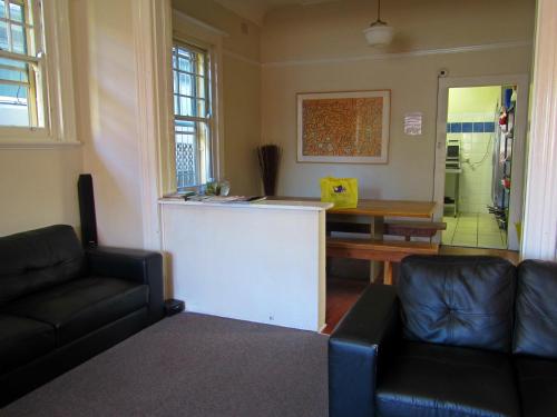 a living room with a couch and a counter at Manly Bunkhouse in Sydney