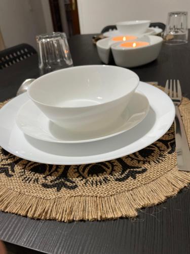 a white bowl on a plate on a table at Casa Vacanza Rosati in Cerignola