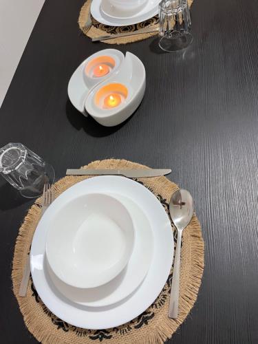 een zwarte tafel met witte borden en een ei erop. bij Casa Vacanza Rosati in Cerignola