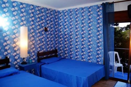 a bedroom with two beds and a blue wall at Santiago Mallorca in Cala Figuera
