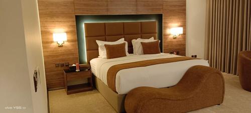 a hotel room with a large bed and a chair at فندق بلفيو بارك رويال Bellevue Park Royal Hotel in Taif