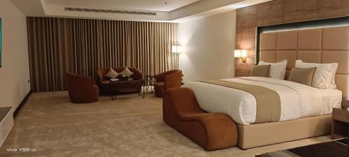 a hotel room with a large bed and a chair at فندق بلفيو بارك رويال Bellevue Park Royal Hotel in Taif