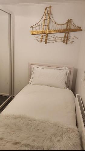 1 dormitorio con 1 cama blanca y un puente en la pared en Deluxe room en Basildon