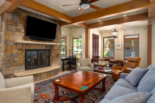 a living room with a stone fireplace and a tv at The Porches in Steamboat Springs
