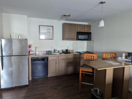 a kitchen with a stainless steel refrigerator and wooden floors at Quality Inn & Suites Northampton - Amherst in Northampton