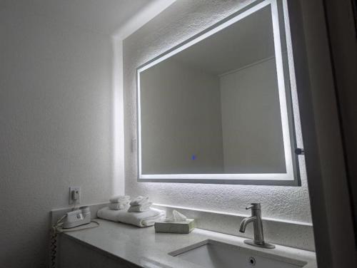 a bathroom with a sink and a large mirror at Quality Inn & Suites Northampton - Amherst in Northampton