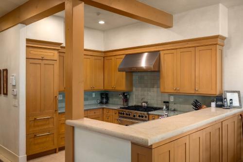 cocina con armarios de madera y horno con fogones en The Porches, en Steamboat Springs