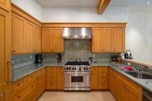 a kitchen with wooden cabinets and a stove top oven at The Porches in Steamboat Springs