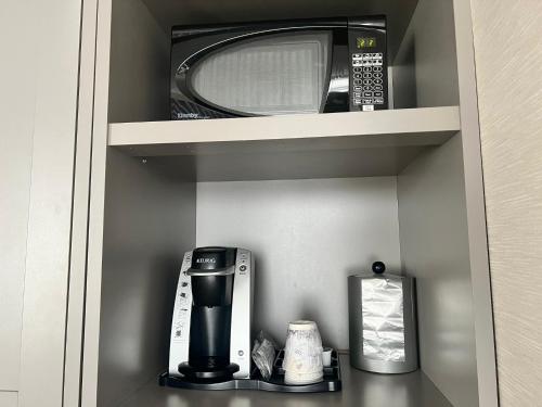 a coffee maker and a microwave on a shelf at Holiday Inn Toronto Airport East by IHG in Toronto