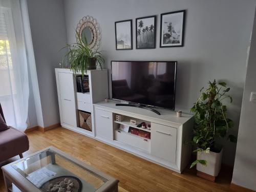 a living room with a white entertainment center with a television at Piso acogedor con terraza in Ciudad Real