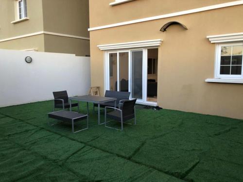 a patio with a table and chairs on a lawn at Alwaha luxury Villa 5 Bedrooms فيلا الواحه in King Abdullah Economic City